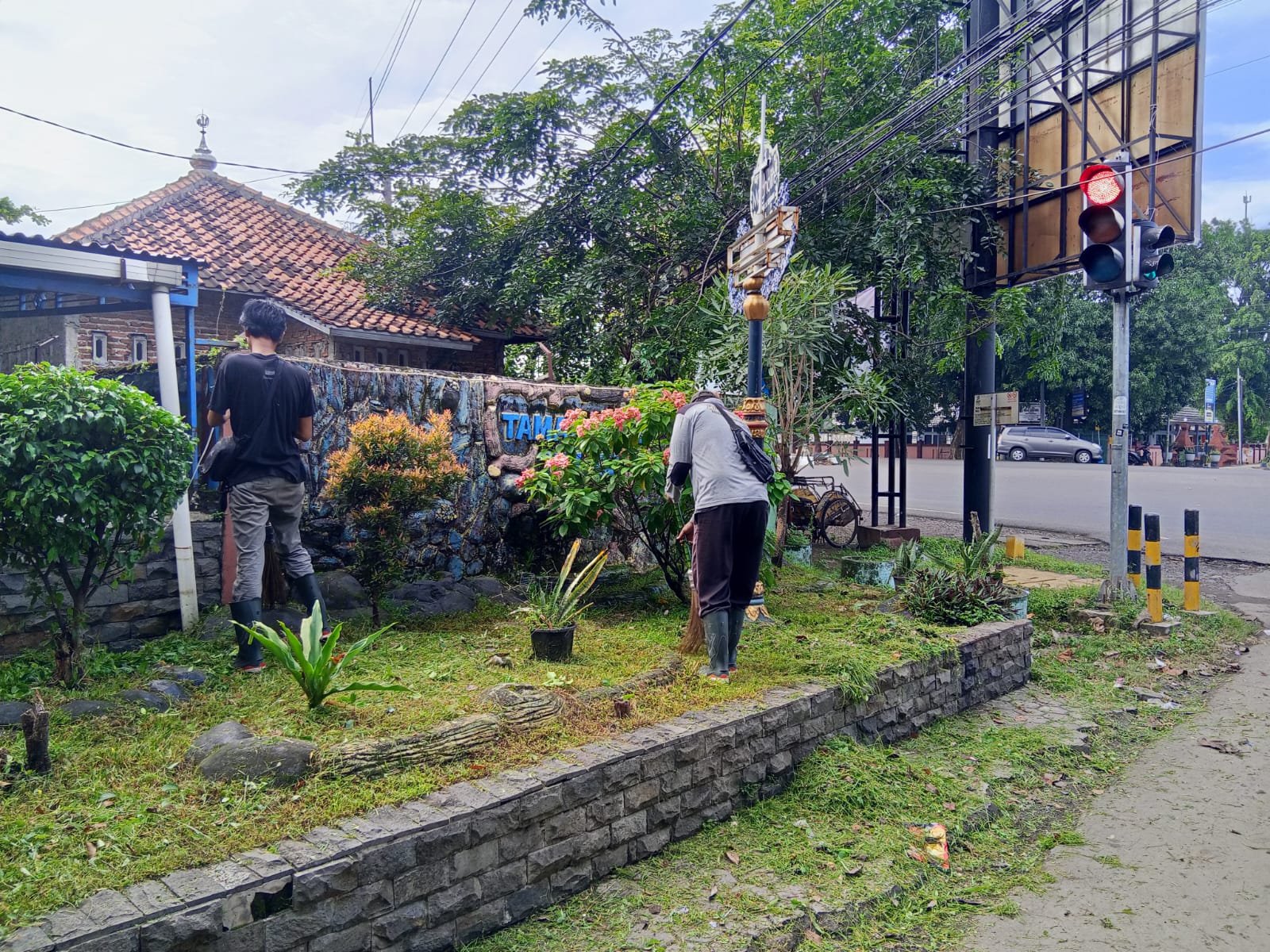 Satuan Tugas Kebersihan tengah membersihkan Taman RW